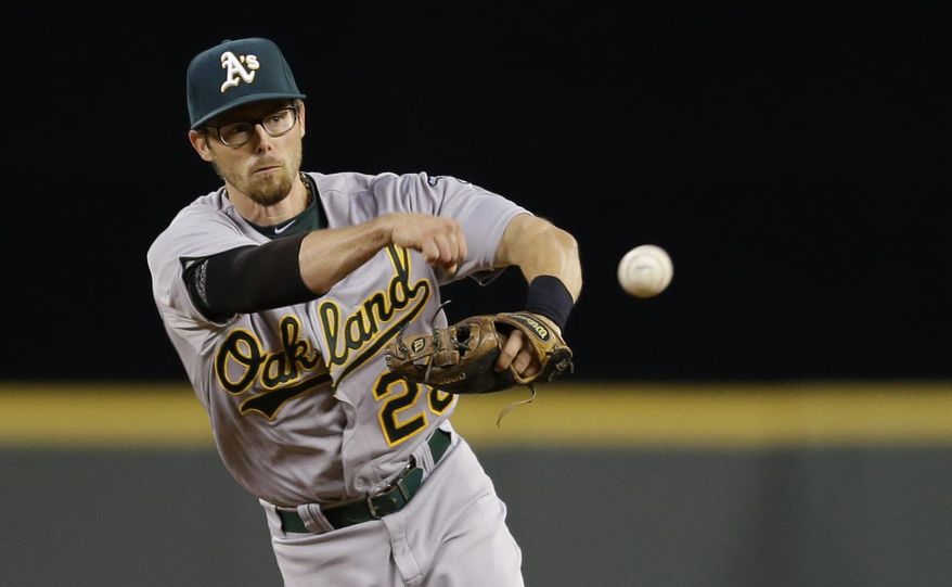Oakland Athletics second baseman Eric Sogard throws out Seattle Mariners&#x27; Corey Hart at first base to end the third inning of a baseball game, Friday, April 11, 2014, in Seattle. (AP Photo/Ted S. Warren)