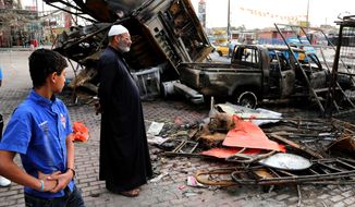 Iraqi civilians inspect debris left in the aftermath of a car bombing on a commercial street in Baghdad&#39;s eastern neighborhood of Sadr City, Iraq, Friday, April 11, 2014. Two car bombs exploded in Shiite neighborhoods of Iraq&#39;s capital Thursday night, killing and wounding scores of people, as violence roars on before a crucial election later this month, authorities said. Last year, Iraq weathered its deadliest bout of violence since it pulled back from the brink of civil war in 2008. (AP Photo/Karim Kadim)