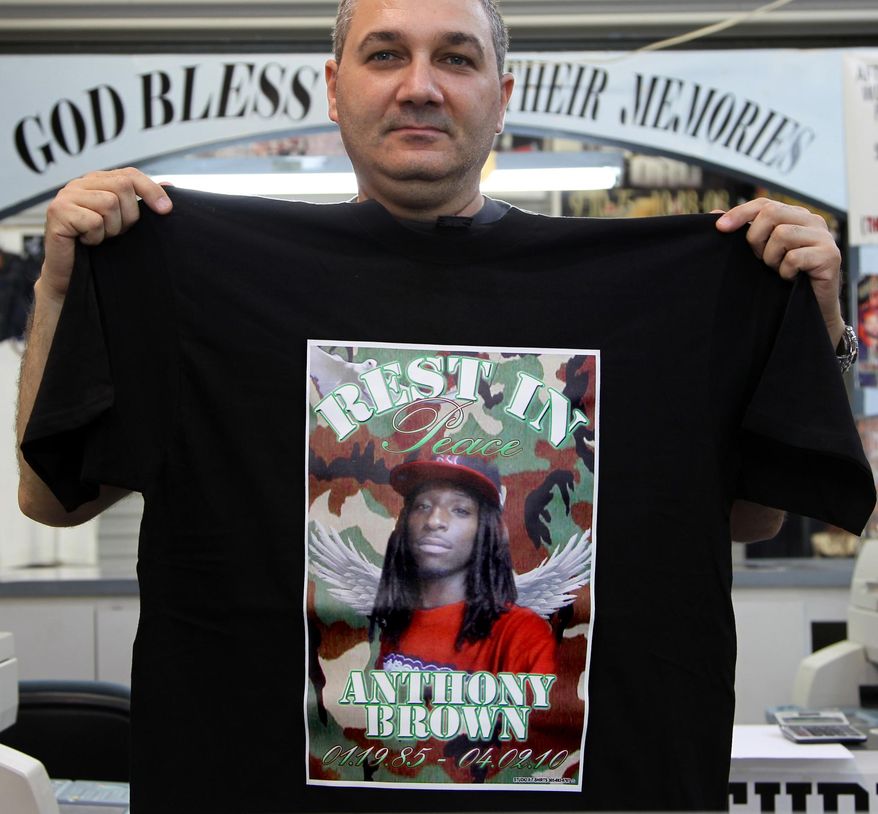 Studio X owner Hai Haliva shows one of the T-shirts produced by his store on Thursday, April 3, 2014. At Studio X, inside the U.S.A. Flea Market, miles away from South Beach in a gritty pocket of Liberty City, is where black Miami’s killed are memorialized. Pictures of the deceased are stamped onto plaques and necklace charms, but a majority of customers come to put a picture on a T-shirt. (AP Photo/The Miami Herald, Carl Juste)