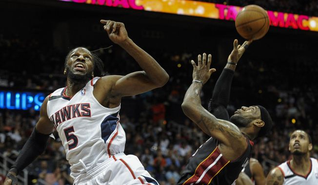 Miami Heat forward LeBron James, front right, is fouled under the basket by Atlanta Hawks forward DeMarre Carroll (5) during the first half of an NBA basketball game on Saturday, April 12, 2014, in Atlanta. (AP Photo/John Amis)