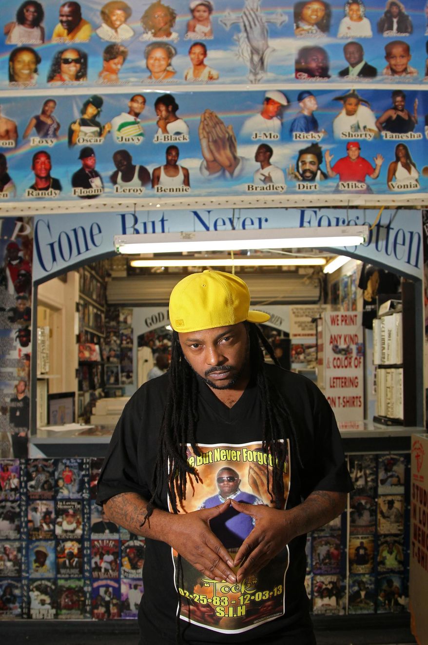 Entertainer Desloc Piccalo, 37, poses for a photo at Studio X, a USA Flea Market store that produces memorial shirts for those who have died, Thursday, April 3, 2014. At Studio X, inside the U.S.A. Flea Market, miles away from South Beach in a gritty pocket of Liberty City, is where black Miami’s killed are memorialized. Pictures of the deceased are stamped onto plaques and necklace charms, but a majority of customers come to put a picture on a T-shirt. (AP Photo/The Miami Herald, Carl Juste)