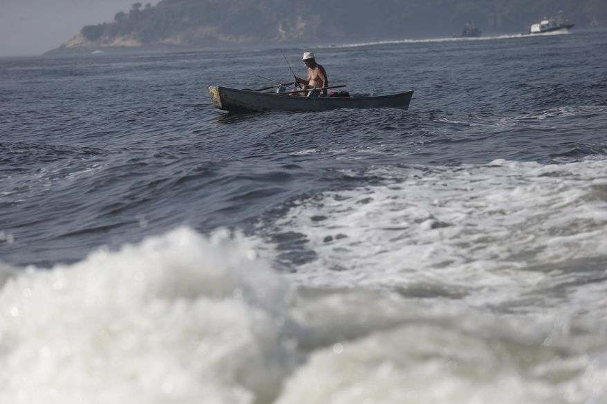 A man fishes on the Guanabara Bay in Rio de Janeiro, Brazil, Thursday, April 10, 2014. Many had hoped authorities tackle decades of neglect and poor planning that have blighted waterways, after Rio's Olympic committee pledged in writing that the pollution problems of Guanabara Bay will be fixed. (AP Photo/Silvia Izquierdo)
