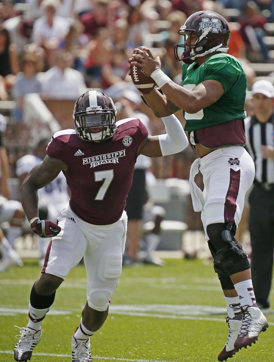 CORRECTS YEAR - Mississippi State Maroon quarterback Dak Prescott (15) pulls down a high snap for running back Nick Griffin (7) during the first half of their spring NCAA college football game against the White squad, Saturday, April 12, 2014, in Starkville, Miss. Maroon won 41-38. (AP Photo/Rogelio V. Solis)