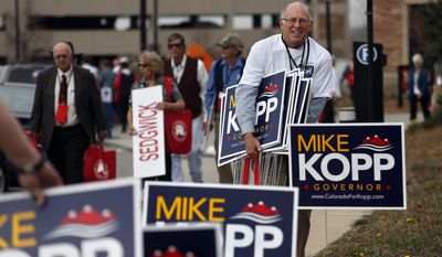 Campaign workers for candidate for Colorado governor Mike Kopp collect signs following the state GOP Congress,  in Boulder, Colo., Saturday, April 12, 2014. Kopp and Colorado Secretary of State Scott Gessler made the ballot in hope of challenging Democratic Gov. John Hickenlooper this fall. (AP Photo/Brennan Linsley)