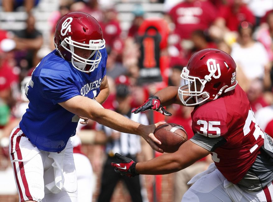 Oklahoma quarterback Justice Hansen (4) hands off a pass to running back Leo Luna (35) during the second half of the annual Oklahoma Spring Football game in Norman, Okla. on Saturday, April 12, 2014. (AP Photo/Alonzo Adams)