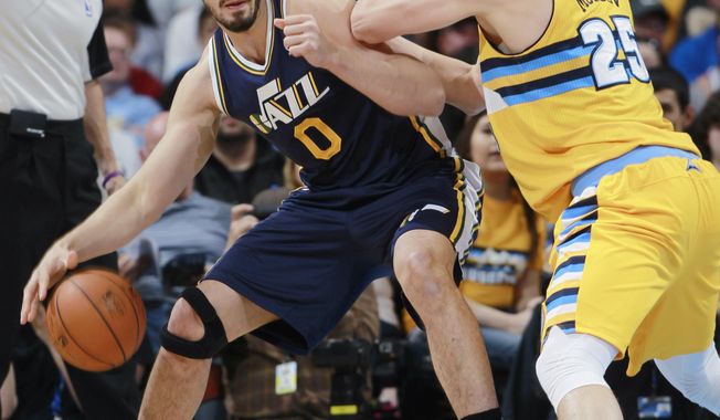 Utah Jazz center Enes Kanter, left, of Turkey, works ball inside as Denver Nuggets center Timofey Mozgov, of Russia, covers in the first quarter of an NBA basketball game in Denver on Saturday, April 12, 2014. (AP Photo/David Zalubowski)