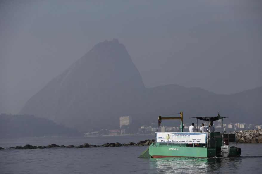 A garbage-collecting barge gathers trash at the Guanabara Bay in Rio de Janeiro, Brazil, Thursday, April 10, 2014. The barge is one of three so-called "eco-boats," floating garbage vessels that are a key part of the authorities' pledge to clean up Rio’s devastated Guanabara Bay before the city – and the waterway itself – plays host to the 2016 Olympic games. (AP Photo/Silvia Izquierdo)