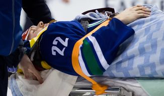 Vancouver Canucks&#39; Daniel Sedin, of Sweden, is taken off the ice on a stretcher after being checked into the boards by Calgary Flames&#39; Paul Byron during second period NHL hockey action in Vancouver,  British Columbia, on Sunday April 13, 2014. (AP Photo/The Canadian Press, Darryl Dyck)