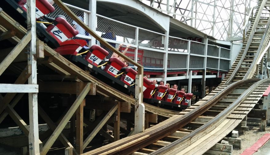 Visitors to Coney Island ride the Cyclone at Luna Park in the Brooklyn borough of New York Sunday, April 13, 2014. The rides of Coney Island opened for another season with the 1920s wooden roller-coaster being christened with a dousing of a traditional egg cream drink. It marked the opening of the 40 rides of Luna Park, where 750 local residents are employed. (AP Photo/Julie Walker)