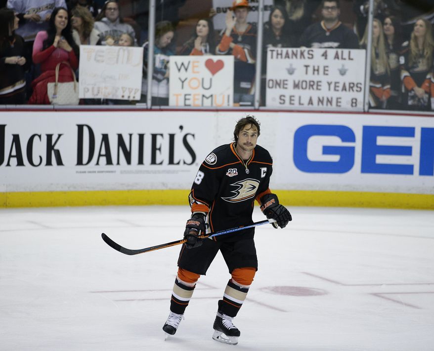 Anaheim Ducks' Teemu Selanne, of Finland, skates by as fans hold up signs for him during practice for an NHL hockey game against the Colorado Avalanche on Sunday, April 13, 2014, in Anaheim, Calif. Selanne plays his final regular-season game Sunday night. (AP Photo/Jae C. Hong)