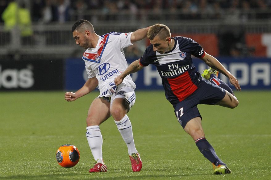 Lyon&#x27;s Jordan Ferri, left, challenges for the ball with Paris Saint Germain&#x27;s Lucas Digne, right, during their French League One soccer match in Lyon, central France, Sunday, April 13, 2014. (AP Photo/Laurent Cipriani)