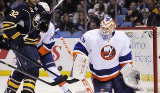 Buffalo Sabres&#39; John Scott (32) battles for a rebound after a save from New York Islanders&#39; Anders Nilsson (45), of Sweden,  during the first period of an NHL hockey game in Buffalo, N.Y., Sunday April 13, 2014. (AP Photo/Gary Wiepert)