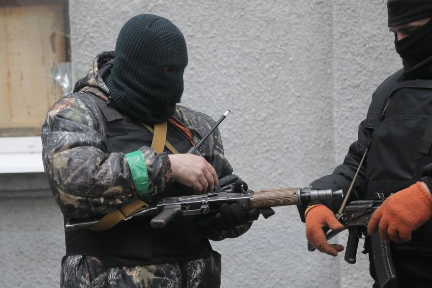 Pro-Russian gunmen check their weapons at a seized police station in the eastern Ukrainian town of Slovyansk on Sunday, April 13, 2014. Ukrainian special forces exchanged gunfire with a pro-Russia militia in the eastern city Sunday, according to the interior minister, who said one Ukrainian security officer was killed and five others wounded. It was the first reported gunbattle in east Ukraine, where armed pro-Russia men have seized a number of law enforcement buildings in recent days. (AP Photo/Efrem Lukatsky)