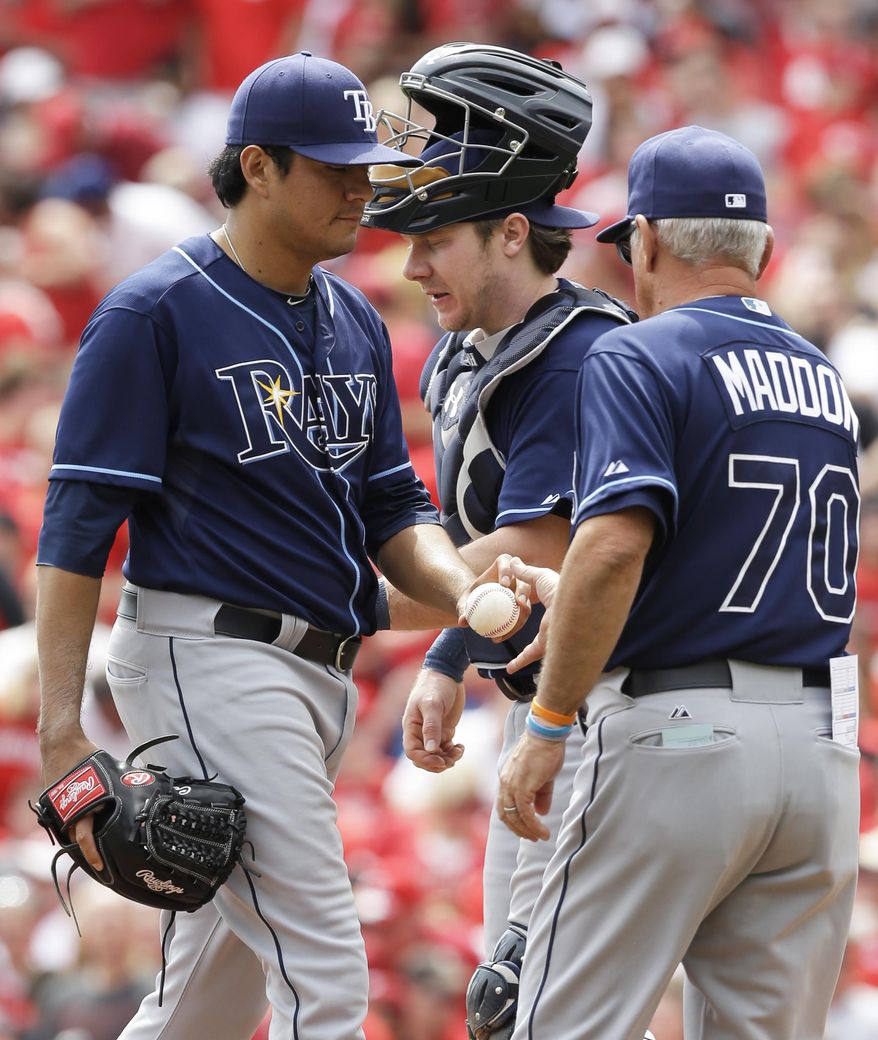 Tampa Bay Rays manager Joe Maddon (70) takes starting pitcher Cesar Ramos, left, out in the third inning of a baseball game against the Cincinnati Reds, Sunday, April 13, 2014, in Cincinnati. Catcher Ryan Hanigan watches. (AP Photo/Al Behrman)