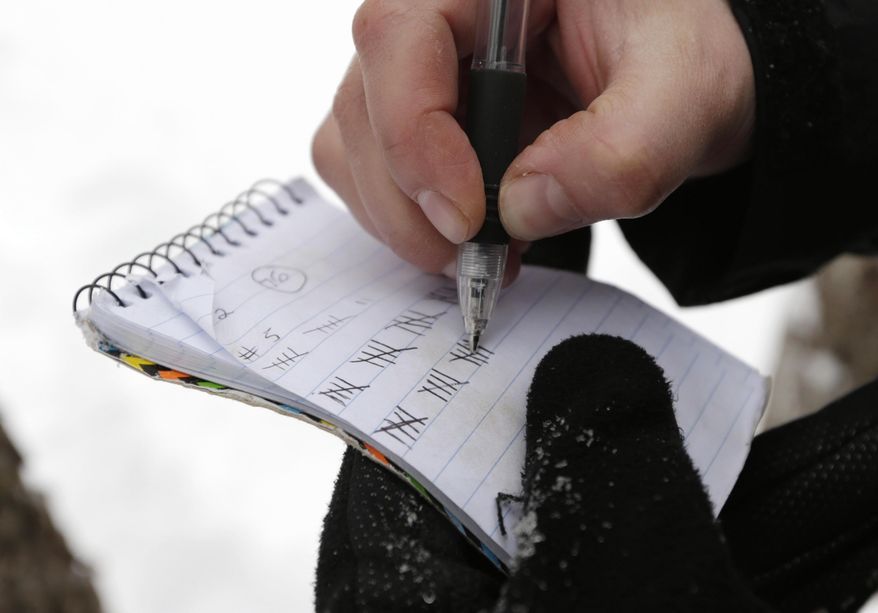 In this photo made Friday, March 21, 2014, Leah Moffitt keeps track of the number of maple trees she has tapped on Passamaquoddy land near Jackman, Maine. The tribe plans to tap 60,000 trees in the hopes of becoming one of the biggest maple syrup operations in Maine. (AP Photo/Robert F. Bukaty)