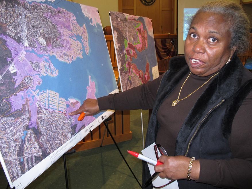 In this March 18, 2014 photo, Celeste Evans of Toms River N.J. points on a map to her section of town that was severely flooded by Superstorm Sandy. She was at a hearing at the Toms River municipal building for residents to make suggestions on how to protect against future storms. Ideas included building dunes, adding bulkheading, better securing boats and floating docks, and monitoring the slope of homeowners' properties to avoid channeling water into low-lying areas. (AP Photo/Wayne Parry)