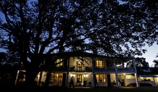 Workers wait outside of the Augusta National Golf Clubhouse in the early morning before the fourth round of the Masters golf tournament Sunday, April 13, 2014, in Augusta, Ga. (AP Photo/Darron Cummings)