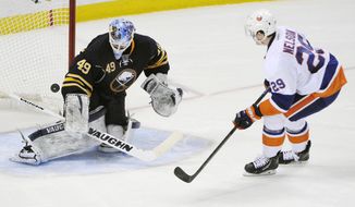 Buffalo Sabres goaltender Connor Knapp (49) gets beat as New York Islanders  center Brock Nelson (29) scores the game winning goal during the team shootout of an NHL hockey game in Buffalo, N.Y., Sunday April 13, 2014. New York won 4-3. (AP Photo/Gary Wiepert)