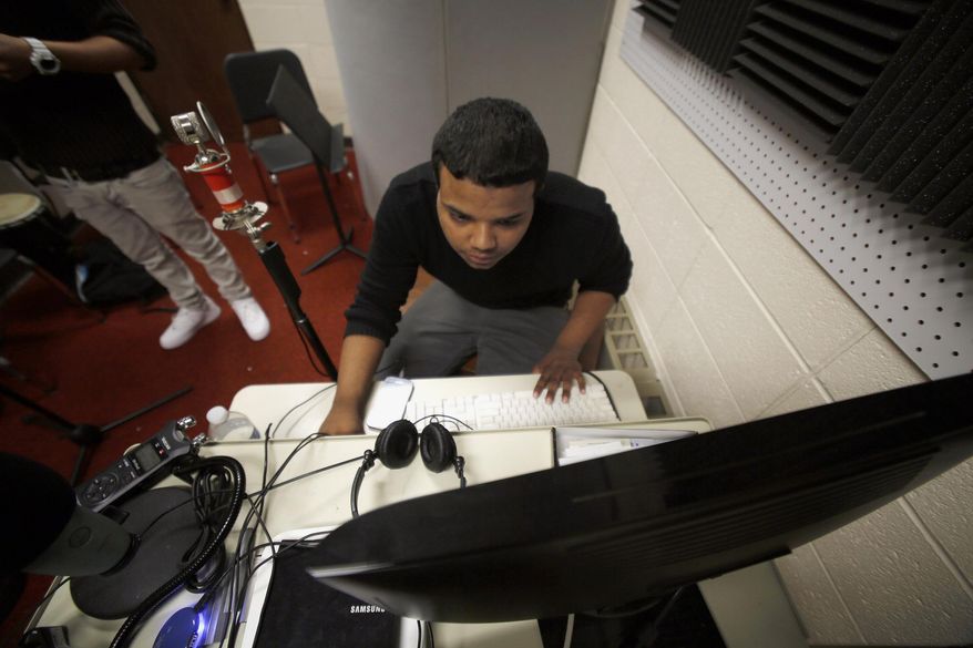 In this March 22, 2014 photo, Miguel Thompson, 16, is seen at the studio at Streamwood High School in Streamwood, Ill., where he has recorded thousands of freestyle rap songs since he started working in the studio as a sophomore. (AP Photo/Daily Herald, Brian Hill) MANDATORY CREDIT, MAGS OUT