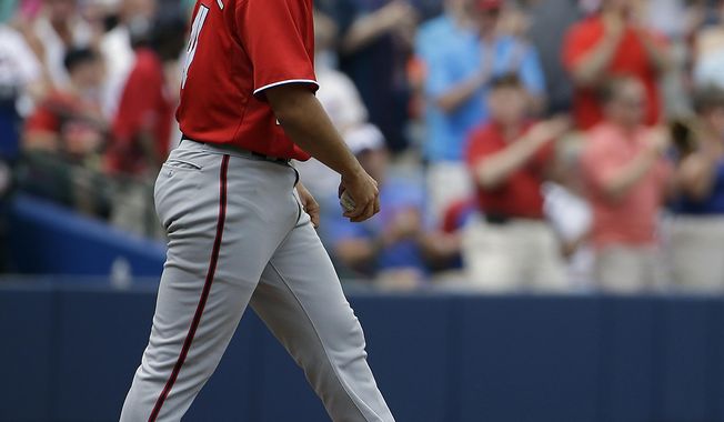 Washington Nationals starting pitcher Gio Gonzalez walks back to the mound after giving up a two-run home run to Atlanta Braves&#x27; Freddie Freeman in the second inning of a baseball game, Sunday, April 13, 2014, in Atlanta. (AP Photo/David Goldman)