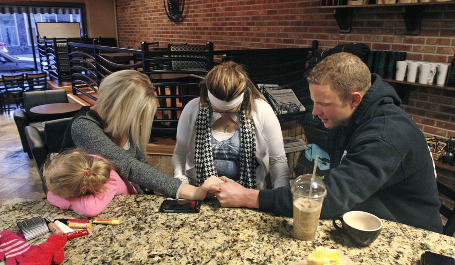 Patrick Johnsen prays with friends at a coffee shop in Williston, N.D. on Wednesday, Feb. 26, 2014. Johnsen, 29, came to the Bakken in 2010 to escape drugs. He'd been heavy into meth and crack back home in the Chicago suburbs and decided to start over, moving to North Dakota. He arrived with a mountain of debts and $11.72 in his pocket. He turned things around, working on an oil rig, and has been sober since September 2012. He attends a twice-weekly support group of recovering substance abusers and stays out of bars. (AP Photo/Martha Irvine)
