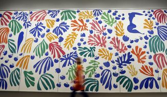 A woman a walks past &#x27;The Parekeet and the Mermaid 1952&#x27; by Henri Matisse, on display during a media opportunity at The Tate Modern in London, Monday, April 14, 2014. The artwork is part of the &#x27;Henri Matisse: The Cut-Outs&#x27; exhibition that runs at the gallery from April 17 until Sept. 7, 2014. (AP Photo/Kirsty Wigglesworth)