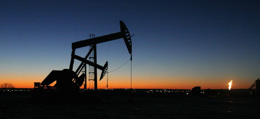 The lights of Williston, N.D. shine in the background of oil pumps on Tuesday, Feb. 25, 2014. Williston is the hub of North Dakota's oil boom - a boom that some say could go on for decades, as new technology has made it possible to drill for oil that had been difficult to reach. (AP Photo/Martha Irvine)