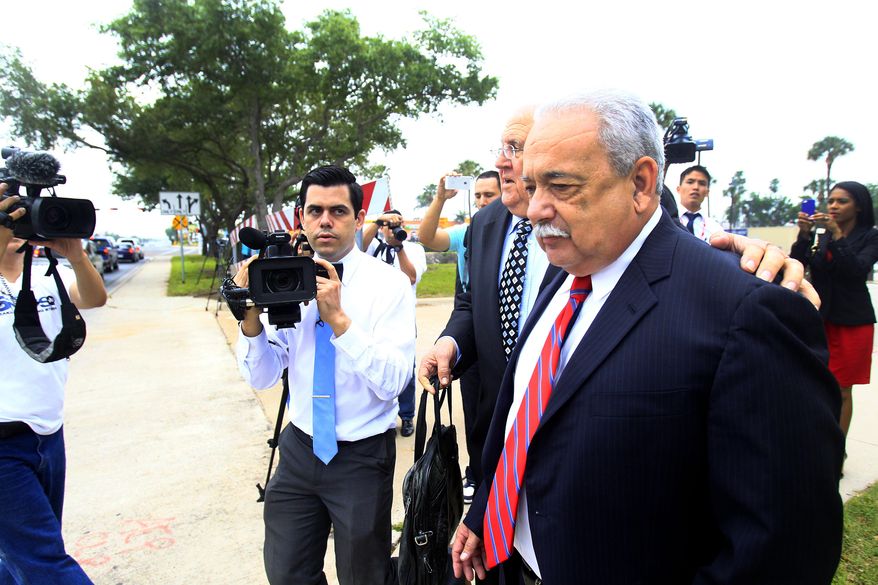 Former Hidalgo County Sheriff Lupe Trevino walks past members of the media with his attorney Robert Yzaguirre after leaving the McAllen Federal Court building, Monday, April 14, 2014, in McAllen, Texas. Trevino pleaded guilty Monday to money laundering and faces a 20-year sentence. He was released on a $30,000 unsecured bond Monday. (AP Photo/The Monitor, Gabe Hernandez)