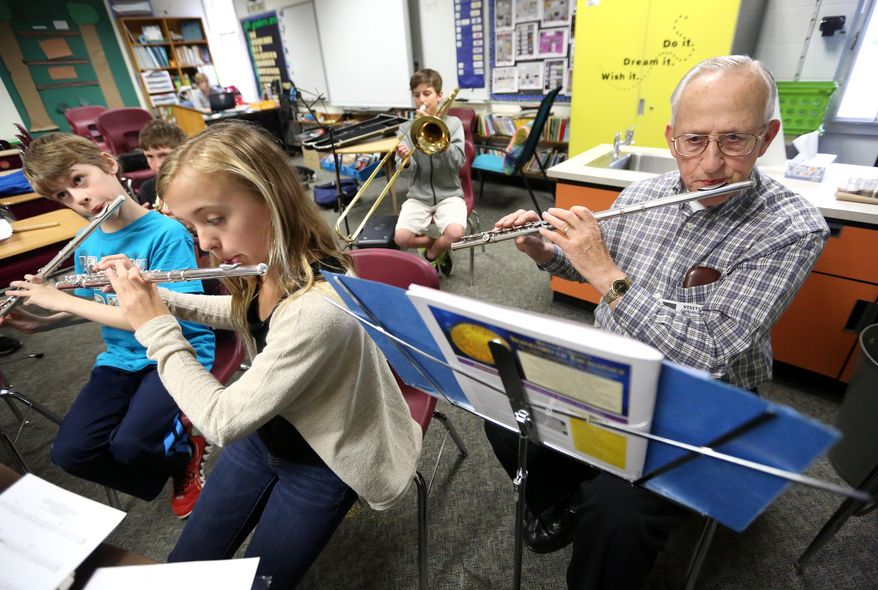 Tony Boland, 79, plays flute during band practice at Kennedy Elementary School Thursday, April 10, 2014, in Dubuque, Iowa. Boland is a volunteer at the school who practices and plays with the school's band. (AP Photo/Telegraph Herald, Jessica Reilly)