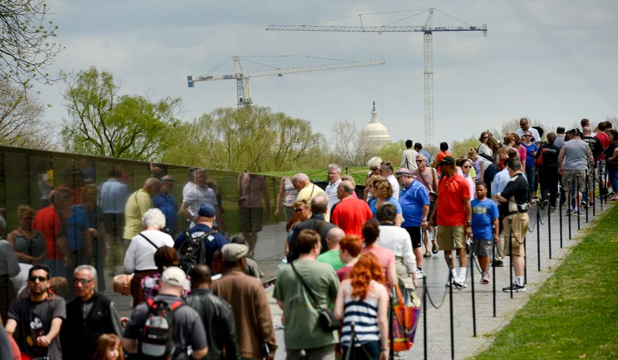 Tourists visit the Vietnam War Memorial on the National Mall, Washington, D.C., Monday, April 14, 2014. (Andrew Harnik/The Washington Times)
