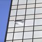 A piece of glass dangles from the Centennial Tower office building, Tuesday, April 15, 2014, in Atlanta. Atlanta Fire Rescue officials and police blocked off part of Marietta Street while responding to a report of glass falling from the downtown Atlanta office building. Details on what caused the glass to fall and what floor the glass fell from were not immediately available. Police say no injuries have been reported. (AP Photo/David Goldman)