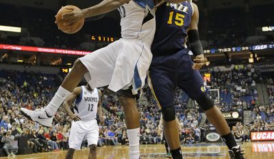 Minnesota Timberwolves center Ronny Turiaf, left, of France, pulls down a rebound against Utah Jazz center Derrick Favors (15) during the second quarter of an NBA basketball game in Minneapolis, Wednesday, April 16, 2014. (AP Photo/Ann Heisenfelt)