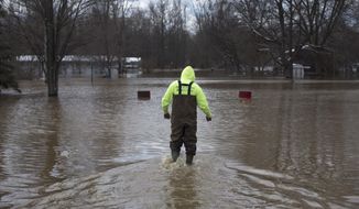 Neil Hock, 44, wades through floodwater in Sanford, Mich., Tuesday, April 15, 2014. Several Michigan rivers are over their banks after three days of storms dropped as much of 5.5 inches of rain, forcing some flood plain residents from their homes. Hock evacuated April 14 after the waters flooded his home.(AP Photo/The Saginaw News, Tim Goessman) ALL LOCAL TV OUT; LOCAL TV INTERNET OUT