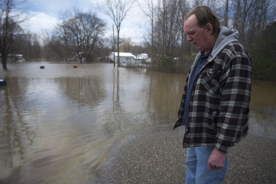 Jeff Snyder, 59, smokes a cigarette in Sanford, Mich., Tuesday, April 15, 2014. Several Michigan rivers are over their banks after three days of storms dropped as much of 5.5 inches of rain, forcing some flood plain residents from their homes. Snyder evacuated his home April 14 after flood waters rose to shoulder height in some areas. Snyder said he was worried his guitars were ruined by the flood waters. (AP Photo/The Saginaw News, Tim Goessman) ALL LOCAL TV OUT; LOCAL TV INTERNET OUT