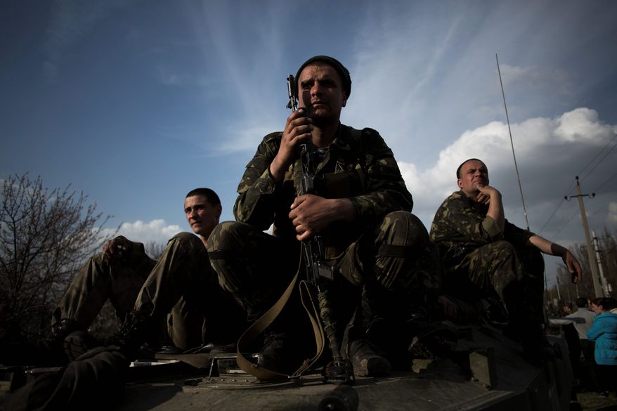 Soldiers of the Ukrainian Army sit atop combat vehicles as they are blocked by people on their way to the town of Kramatorsk on Wednesday, April 16, 2014. Pro-Russian insurgents commandeered six Ukrainian armored vehicles along with their crews and hoisted Russian flags over them Wednesday, dampening the central government's hopes of re-establishing control over restive eastern Ukraine. (Associated Press)