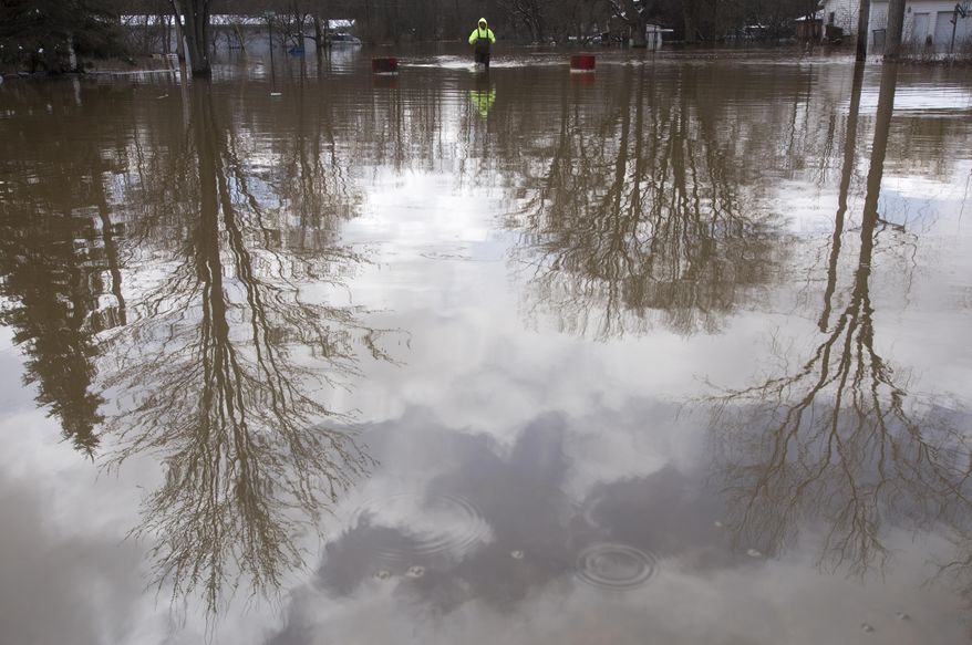 Neil Hock, 44, wades through flood water in Sanford, Mich., Tuesday, April 15, 2014. Several Michigan rivers are over their banks after three days of storms dropped as much of 5.5 inches of rain, forcing some flood plain residents from their homes. Hock evacuated April 14 after the waters flooded his home.(AP Photo/The Saginaw News, Tim Goessman) ALL LOCAL TV OUT; LOCAL TV INTERNET OUT