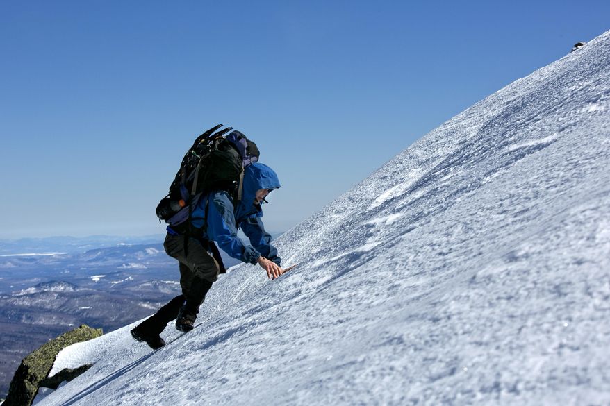 In this Friday, April 4, 2014 photo, Joe Murdzek scrambles up a snowfield while climbing Mount Adams in the Northern Presidential Range of the White Mountains in New Hampshire. Murdzek, 47, of East Hartford, Conn, and three high school friends have made a tradition of getting away on overnight climbing trips as a way to "hit the reset button" from the daily grind. (AP Photo/Robert F. Bukaty)
