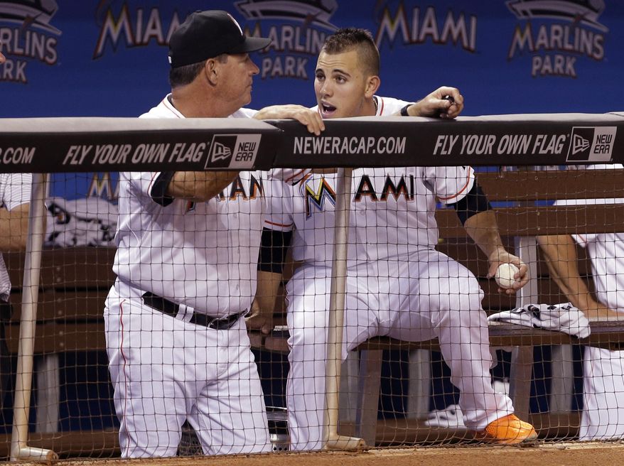 Miami Marlins starting pitcher Jose Fernandez, right talks with pitching coach Chuck Hernandez, left, during the ninth inning of a baseball game against the Washington Nationals, Wednesday, April 16, 2014, in Miami. Fernandez took the loss as the Nationals defeated the Marlins 6-3. (AP Photo/Lynne Sladky)