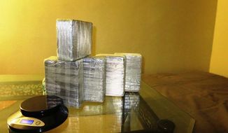In this April 14, 2014 photo provided by the Office of the Special Narcotics Prosecutor for the City of New York, five kilograms of heroin found between a mattress and box spring of a bed in a New York City apartment is shown during a raid by Drug Enforcement Administration agents. Three men were arrested in the major drug bust that recovered more than $12 million in heroin and $500,000 in crystal meth from inside hidden compartments within two New York City apartments. (AP Photo/Office of the Special Narcotics Prosecutor for the City of New York)