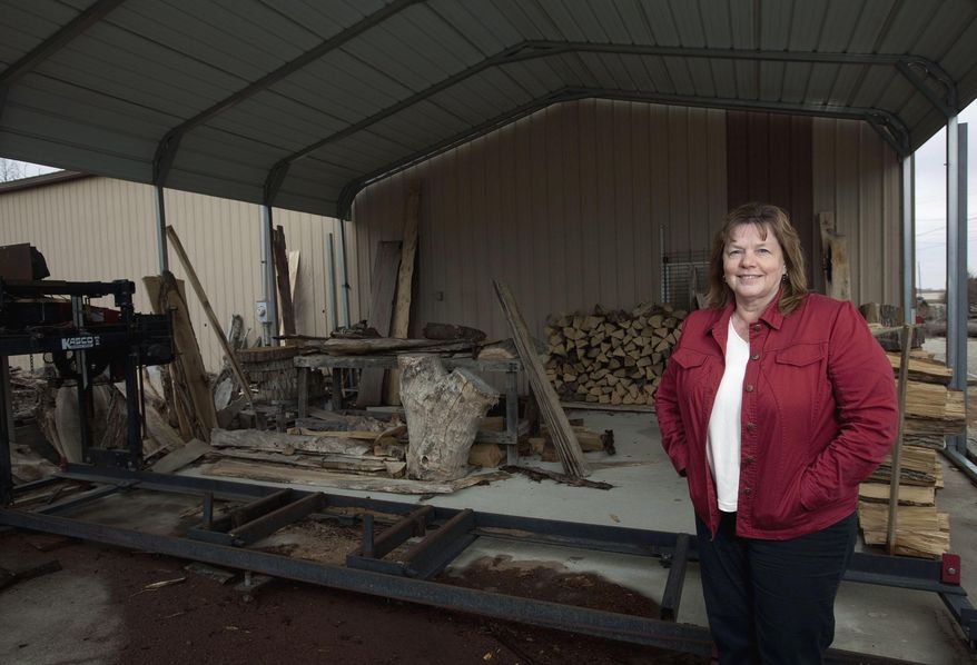 In this March 27, 2014 photo, Grace Curry, of Macon, Ill., stands in front of Curry Sawmill in Boody, Ill., which was the brainchild of her husband before he died in 2010. Curry is in the process of deciding what to do with the business. (AP Photo/Herald & Review, Danny Damiani)