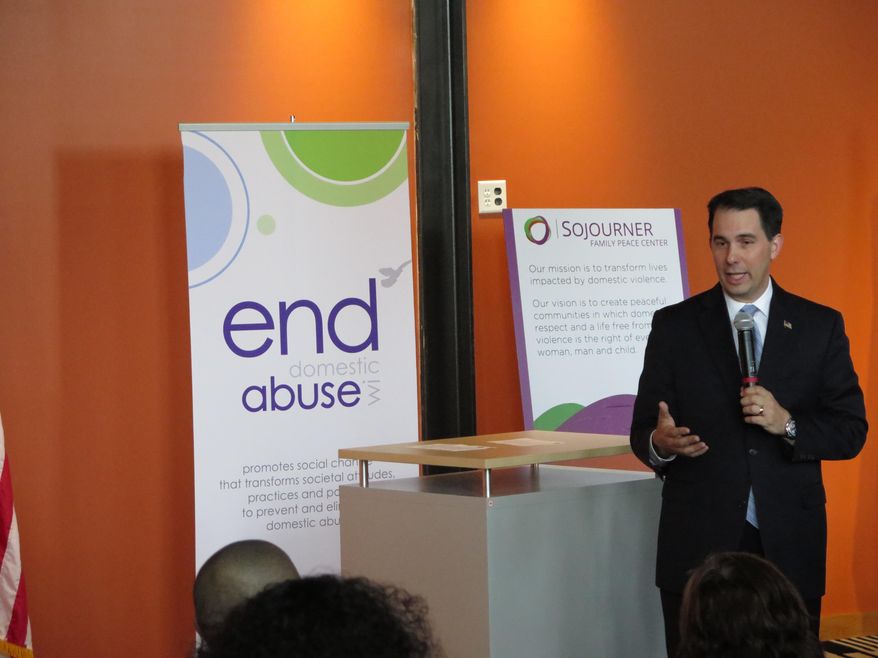 Wisconsin Gov. Scott Walker speaks to supporters of domestic-violence victims on Wednesday, April 16, 2014, in Milwaukee, just before signing three bills aimed at strengthening domestic-violence laws. The measures increase police responsibilities when investigating domestic disturbances and also establish a clear, accountable process for seizing an abuser's guns. (AP Photo/Dinesh Ramde)