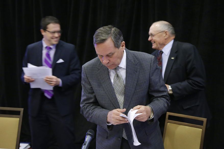 Jeff Lamberti, center, head of the Iowa Racing and Gaming Commission, reads notes on his desk as commission administrator Brian Ohorilko, left, and commissioner Rich Arnold, right, joke behind him, during a break in the commission hearing in Council Bluffs, Iowa, Thursday, April 17, 2014. The commission decided to reject the proposed $164 million Cedar Rapids casino, saying a new casino would hurt existing ones. (AP Photo/Nati Harnik)