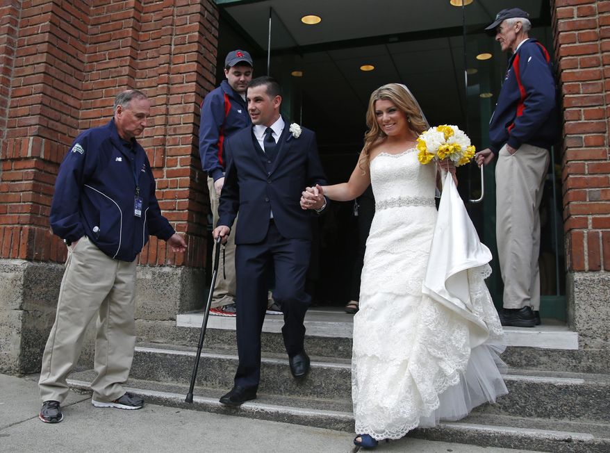 Boston Marathon bombing survivor Marc Fucarile and his bride, Jennifer Regan, leave after their wedding ceremony at Fenway Park in Boston, Thursday, April 17, 2014. Fucarile, a 35-year-old roofer, lost his right leg from above the knee in the bombing. (AP Photo/Elise Amendola)
