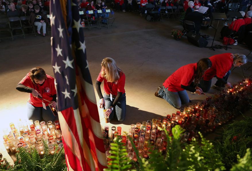 Committee members light candles made by middle school students that will be used in a Healing walk Friday before the start of the 4-17 Forever Forward ceremony, Thursday, April 17, 2014, in West, Texas. Today marks the one-year anniversary of the explosion. (AP Photo/Waco Tribune Herald, Rod Aydelotte)