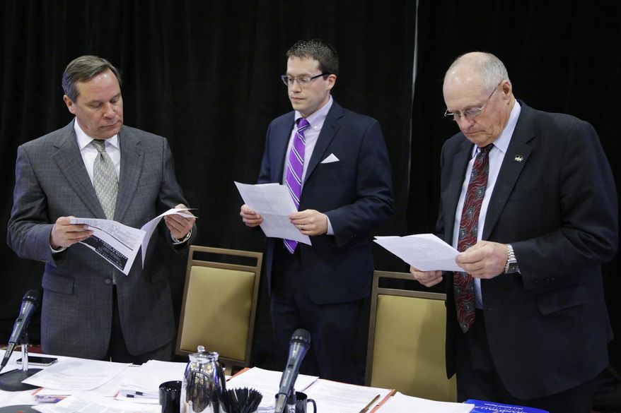 Jeff Lamberti, head of the Iowa Racing and Gaming Commission, left, commission administrator Brian Ohorilko, center, and commissioner Rich Arnold, right, examine papers during a break in the commission hearing in Council Bluffs, Iowa, Thursday, April 17, 2014. The commission decided to reject the proposed $164 million Cedar Rapids casino, saying a new casino would hurt existing ones. (AP Photo/Nati Harnik)