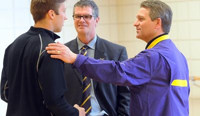 Minnesota State, Mankato football coach Todd Hoffner, right, and athletic director Kevin Buisman talk with defensive back Samuel Thompson after a news conference Thursday, April 17, 2014, in Mankato, Minn. players ended their boycott of spring practice and said Thursday they will play for coach Todd Hoffner, who was reinstated after being exonerated of having child pornography on his cellphone. (AP Photo/Mankato Free Press, Pat Christman)