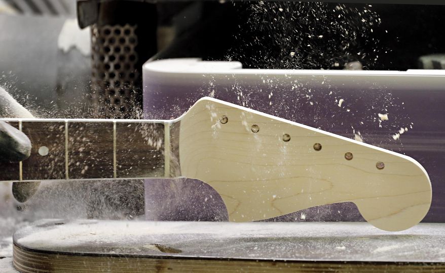 A Fender Stratocaster electric guitar head stock is sanded at the Fender factory in Corona, Calif. on Tuesday, Oct. 15, 2013. The instrument, used by countless professional and amateur musicians, celebrates its 60th anniversary in 2014. (AP Photo/Matt York)