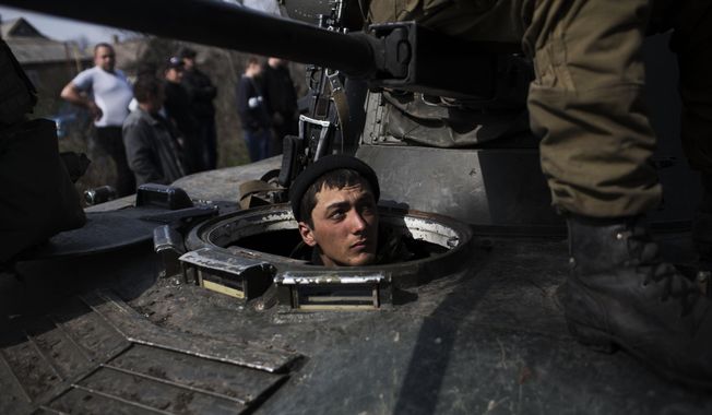A Ukrainian soldier is seen in a tank of the Ukrainian Army, as they are blocked by people on their way to the town of Kramatorsk on Wednesday, April 16, 2014. Pro-Russian insurgents commandeered six Ukrainian armored vehicles along with their crews and hoisted Russian flags over them Wednesday, dampening the central government&#x27;s hopes of re-establishing control over restive eastern Ukraine. (AP Photo/Manu Brabo)