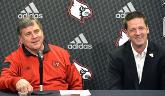 Louisville athletic director Tom Jurich, left, and Jim Murphy, NCAA sports marketing director with Adidas, attend a news conference Thursday, April 17, 2014, in Louisville, Ky. Louisville has announced the extension of its partnership with sports apparel maker Adidas, which will continue to outfit all 23 programs and include additional uniform combinations for the Cardinals’ football team. (AP Photo/Timothy D. Easley)