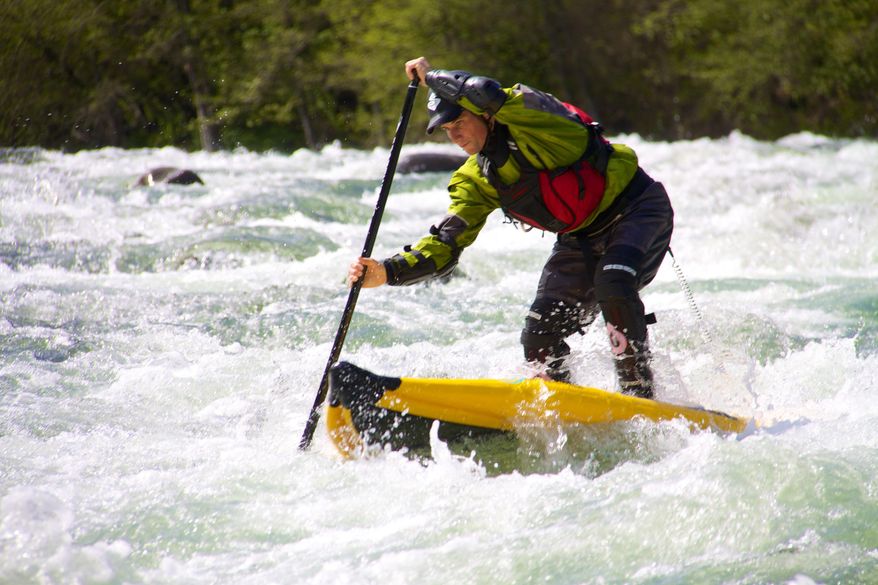 Tim Thornton paddles his stand up paddleboard down the Hood River, near Hood River, Ore., in this 2013 photo. Whether it’s the ocean or estuaries, alpine lakes or white water streams, the number of people floating Oregon waterways on stand up paddleboards has skyrocketed the past two years.(AP Photo/Statesman Journal via White Water Rafting, Zach Collier)